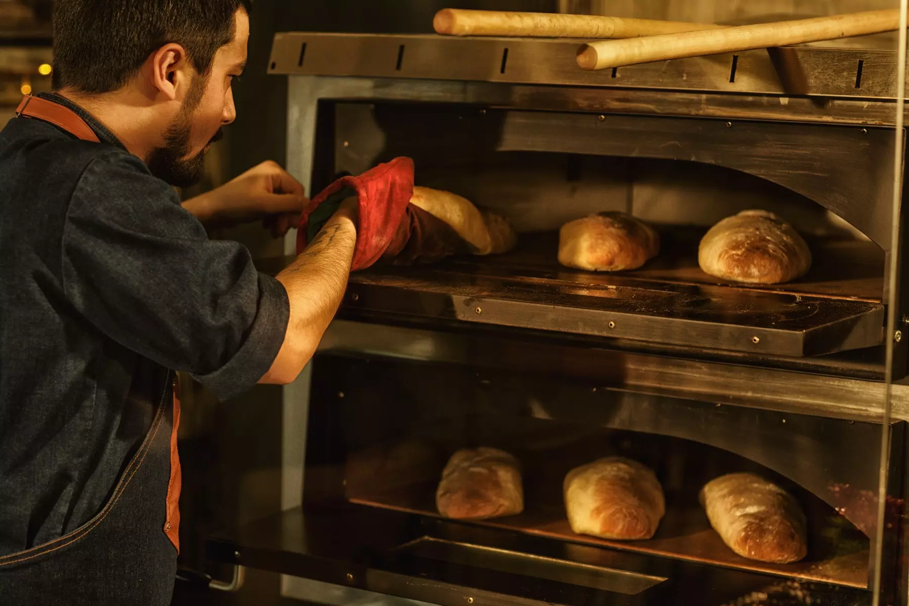 Man baking bread in a commercial convection oven.
