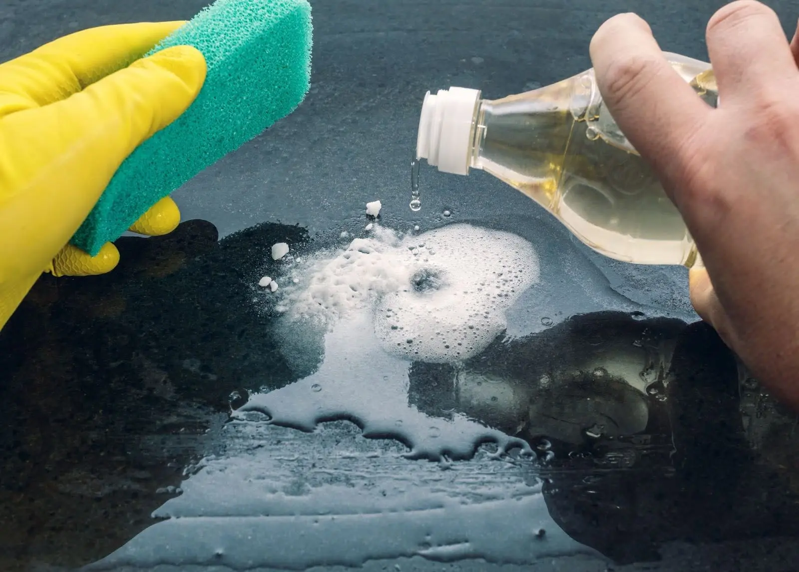 Baking soda and vinegar being used to clean baking sheets