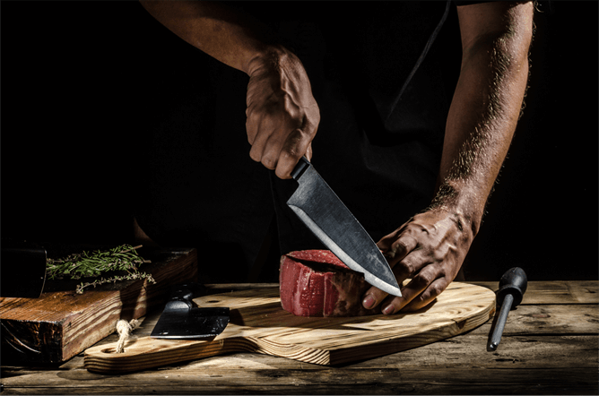 Zanduco - chef cutting meat with a sharp knife