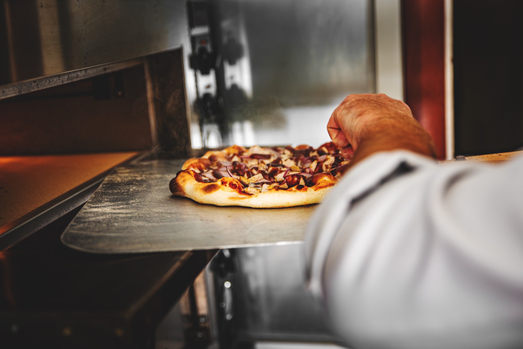 A pizza being cooked in a pizza oven