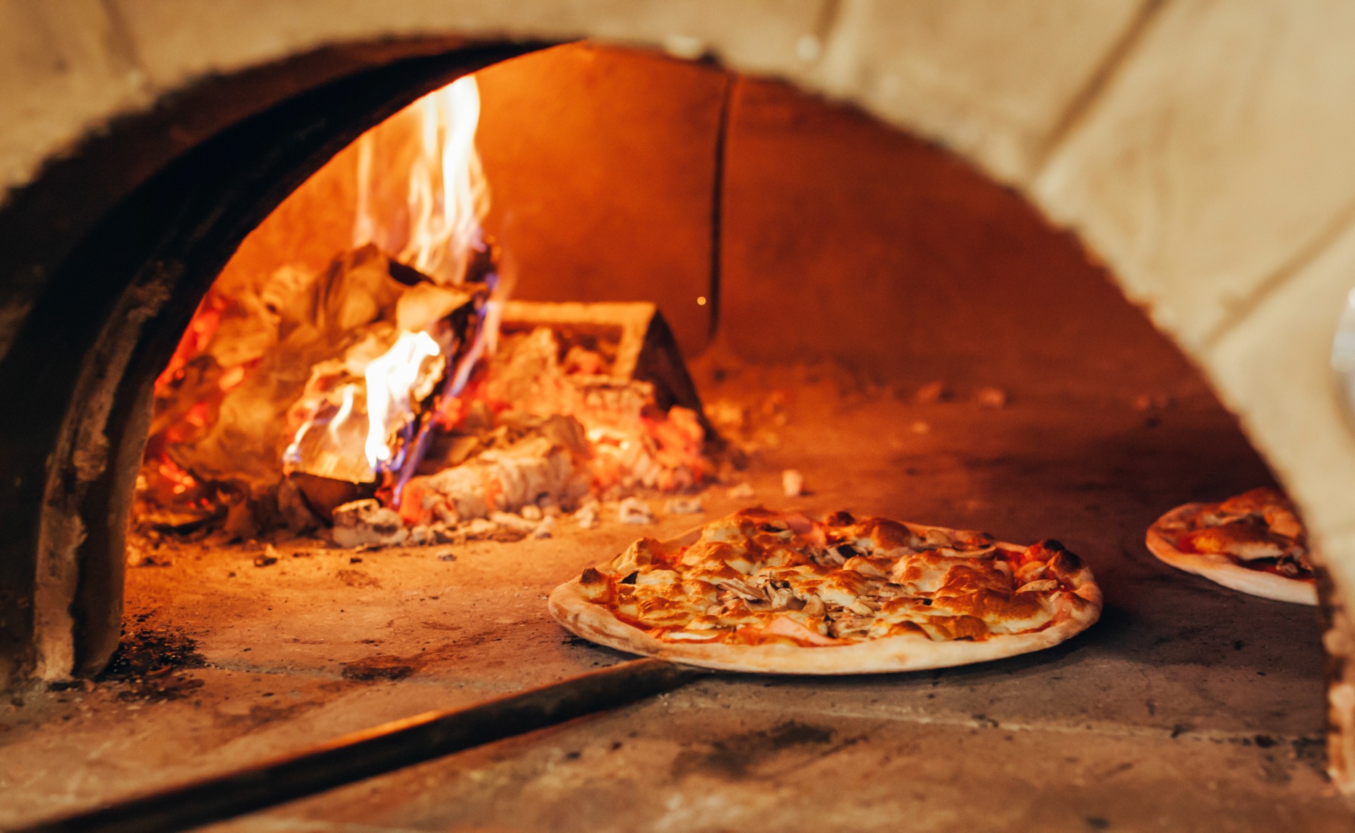 A wood fired pizza oven with a pizza inside